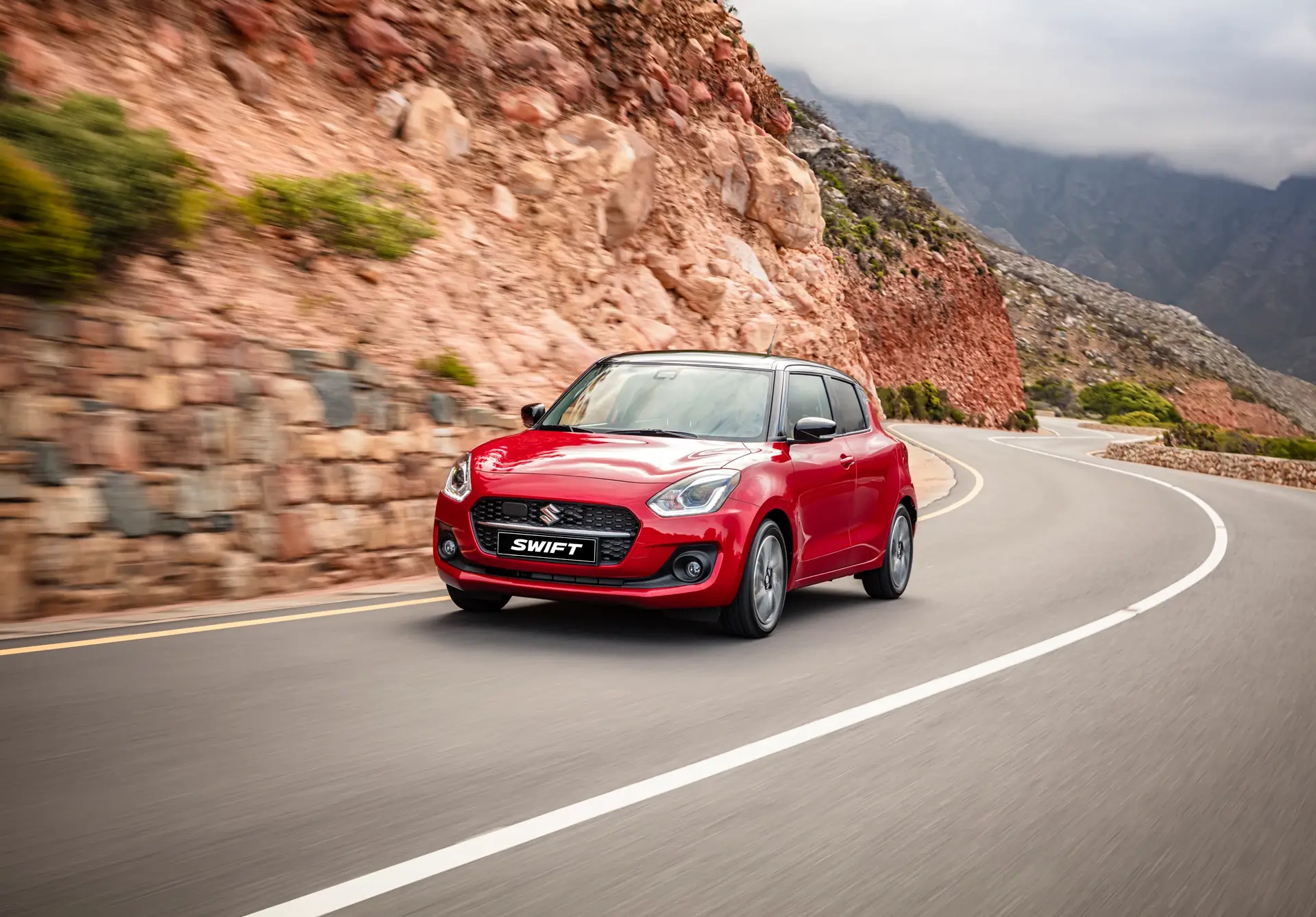 Suzuki Swift on a winding mountain road — illustrative road-trip photograph
